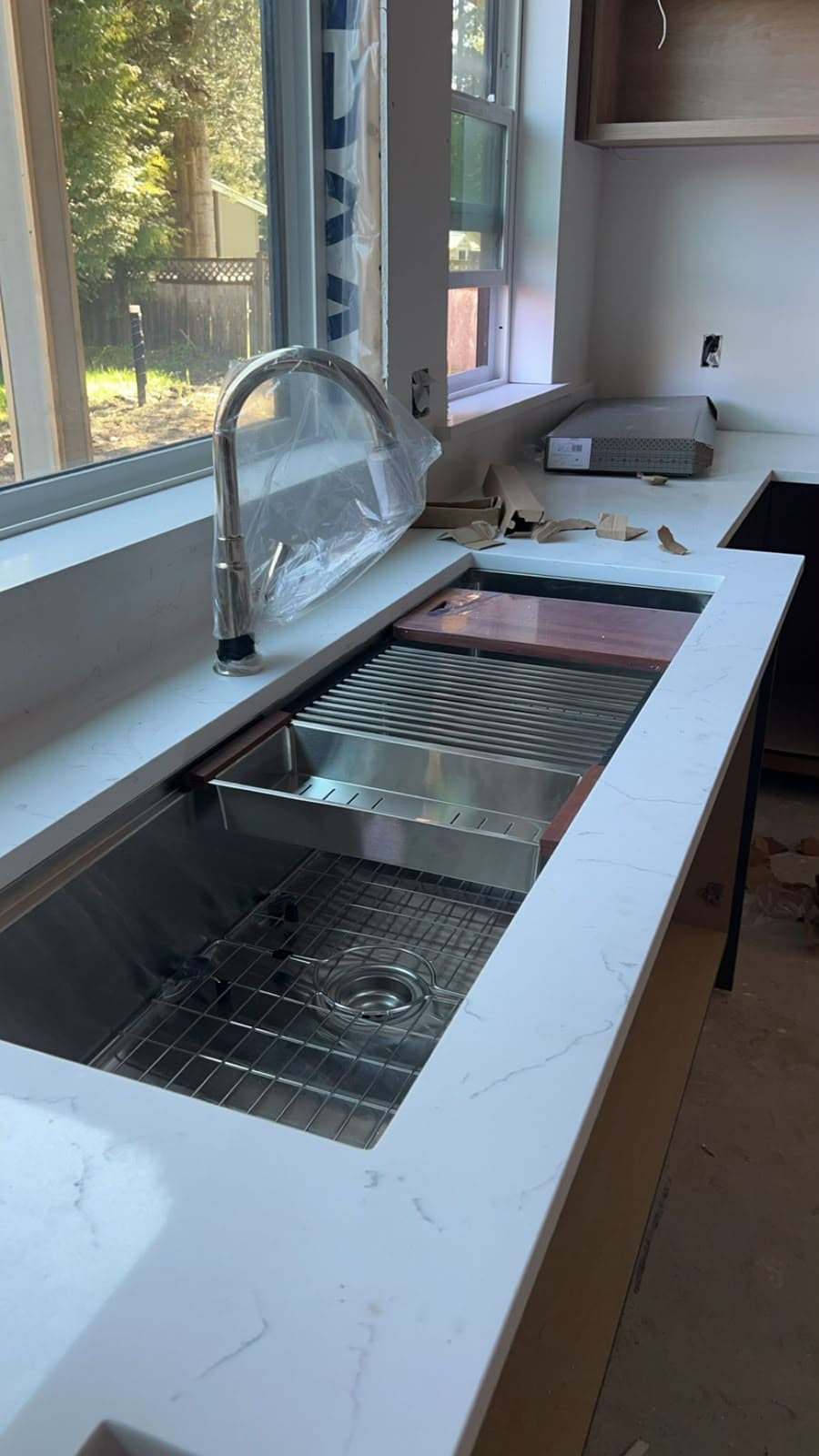 Stainless steel kitchen workstation sink with pull-down faucet during installation