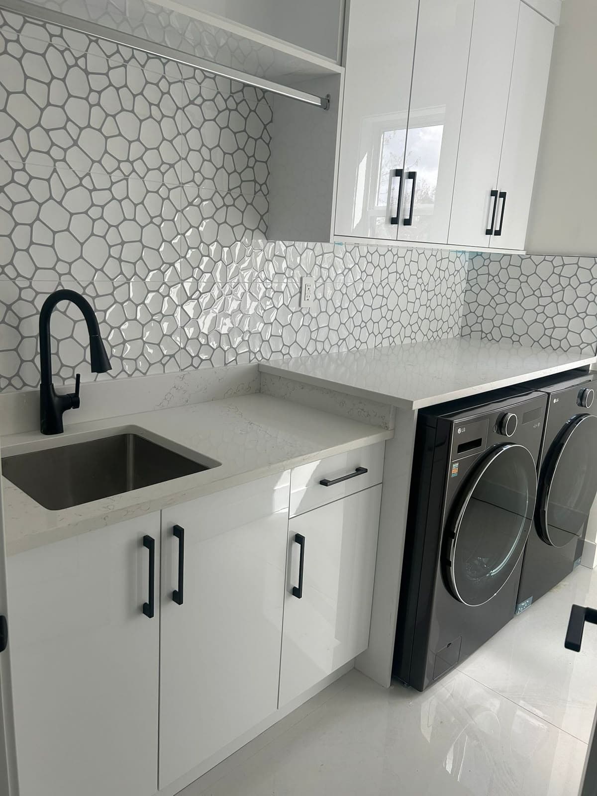 Laundry room utility sink with a matte black pull-down faucet